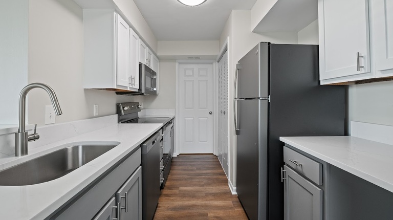 Modern kitchen with quart countertops, updated cabinetry, and slate appliances